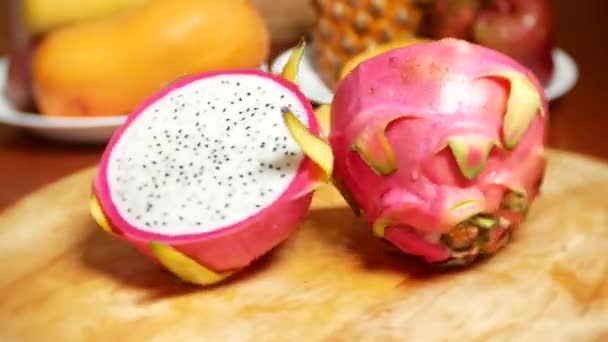 Frutas exóticas na mesa. 4k, o dragonfruit, cortado em pedaços, gira sobre a tábua de corte . — Vídeo de Stock