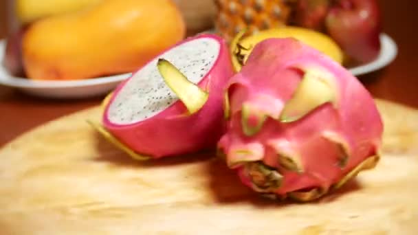 Экзотические фрукты на столе. 4k, плод дракона, разрезанный на куски, вращается на доске . — стоковое видео