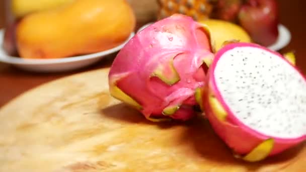 Frutas exóticas na mesa. 4k, o dragonfruit, cortado em pedaços, gira sobre a tábua de corte . — Vídeo de Stock