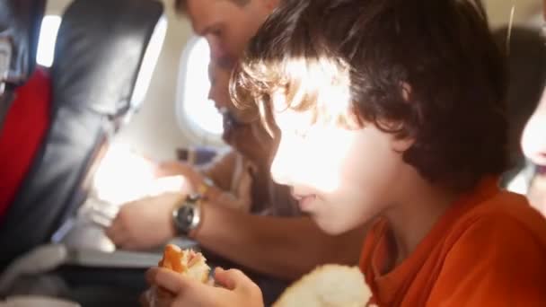 Kinderen, vliegtuig passagiers eten broodjes tijdens de vlucht. 4k — Stockvideo