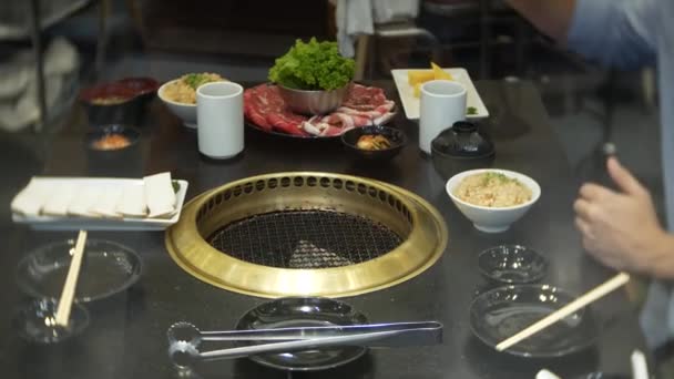 Eten in bulgogi, Koreaanse barbecue, in het restaurant. koken in het Chinese restaurant op de tafel grillen barbecue, 4k, close-up — Stockvideo