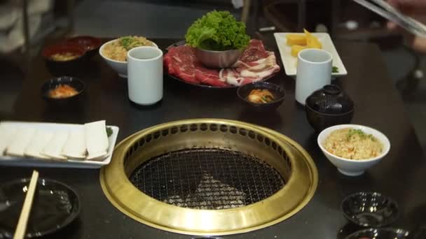 Comida en bulgogi, barbacoa coreana, en el restaurante. cocina en el restaurante chino en la mesa parrilla barbacoa, 4k, primer plano — Vídeos de Stock