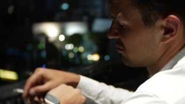 Bir barda sigara genç yalnız bir adam. kol saati 4 k görünüyor