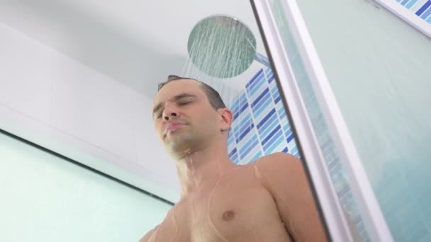 4k, au ralenti. beau jeune homme prend une douche . — Video