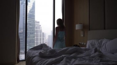 Kadın uykudan uyanır ve manzaralı gökdelenleri, yavaş hareket bir pencere gelir. 4k