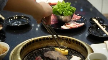Bulgogi, restoranda Korece Barbekü yiyecek. Barbekü, 4 k, yakın çekim ızgara masada Çin restoranında yemek