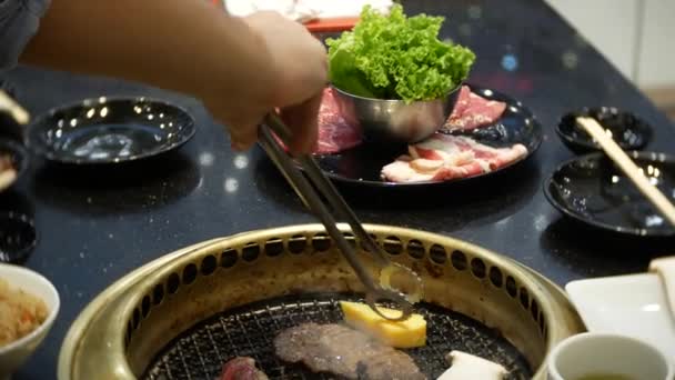 Jídlo v bulgogi, korejské barbecue, v restauraci. vaření v čínské restauraci na stole grilování grilování, 4k, detail — Stock video