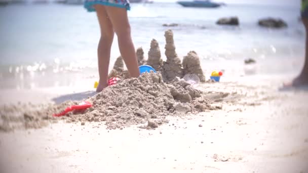 Hrad z písku na pláži, k nepoznání rodina dělá písek hrad na veřejné pláži. 4k, rozostření, pomalý pohyb — Stock video