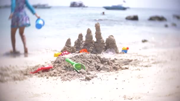 Sandburg am Strand, eine nicht wiedererkennbare Familie baut eine Sandburg an einem öffentlichen Strand. 4k, Unschärfe, Zeitlupe — Stockvideo
