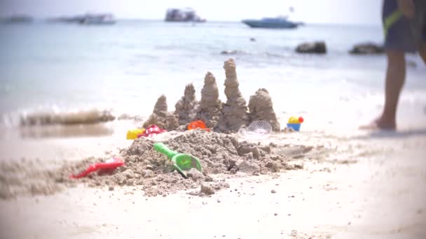 Hrad z písku na pláži, k nepoznání rodina dělá písek hrad na veřejné pláži. 4k, rozostření, pomalý pohyb — Stock video