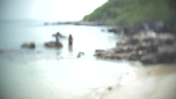 Um par de homens e mulheres irreconhecíveis numa praia selvagem. desfoque, 4k, câmera lenta — Vídeo de Stock