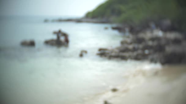 Un paio di uomini e donne irriconoscibili su una spiaggia selvaggia. sfocatura, 4k, rallentatore — Video Stock