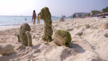 Sahilde denize kıyı, tanınmayan bir aile tarafından atılır, mercan kum kale genel bir kumsalda yürür. 4k, bulanıklık, yavaşlama