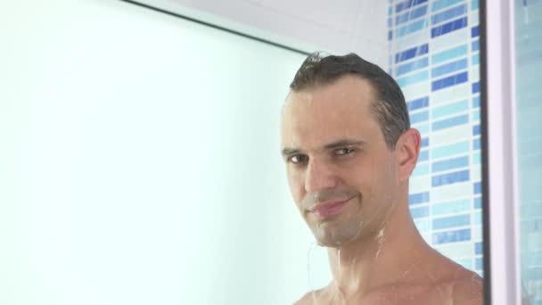 4k, cámara lenta. guapo joven toma una ducha . — Vídeo de stock