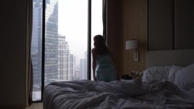 Kadın uykudan uyanır ve manzaralı gökdelenleri, yavaş hareket bir pencere gelir. 4k