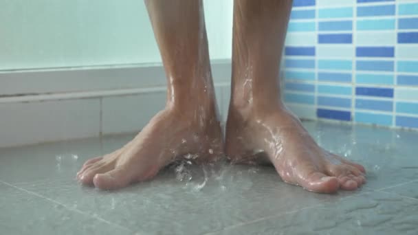 4К, замедленная съемка. Крупный план мужских ног в душе. молодой человек принимает душ . — стоковое видео