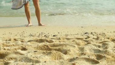 çıplak ayak tropikal kumlu bir plaj üzerinde dinlenme yoldan geçenler tarafından turist. 4k,