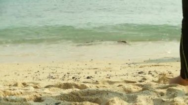 çıplak ayak tropikal kumlu bir plaj üzerinde dinlenme yoldan geçenler tarafından turist. 4k,