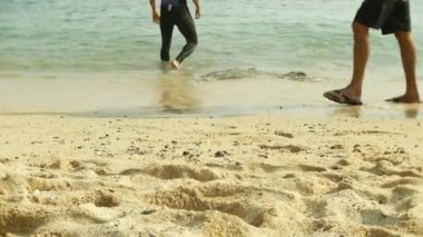 çıplak ayak tropikal kumlu bir plaj üzerinde dinlenme yoldan geçenler tarafından turist. 4k,