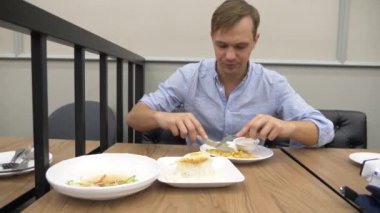 Tayland Mutfağı - pirinç, omlet, domuz eti sebzelerle. bir adam bir restoranda Tayland yemekleri yiyor. 4k, ağır çekim