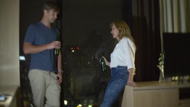 Пара чоловік і жінка п'ють пиво пізно вночі вдома, 4k, повільний рух — стокове відео