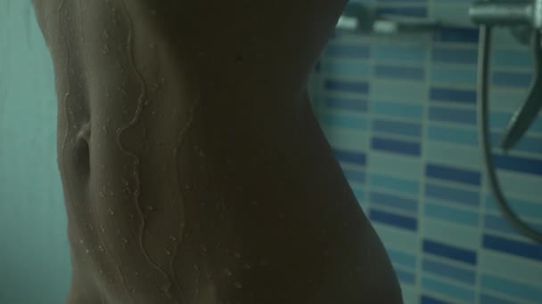 Close-up, en kvindelig slank krop under vandløb. Pigen tager et bad. 4k, langsom bevægelse . – Stock-video
