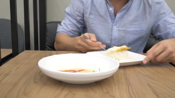 Cozinha tailandesa - arroz, omelete, verduras com o porco. Um homem come comida tailandesa num restaurante. 4k, câmera lenta — Vídeo de Stock