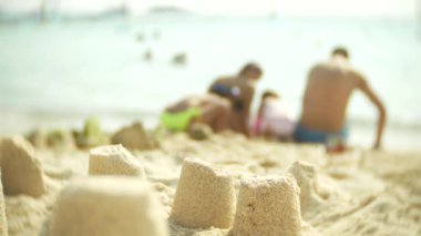 Sahilde, tanınmayan bir aile Kumdan kale halk plajı üzerinde Kumdan kale yapar. 4k, bulanıklık, ağır çekim