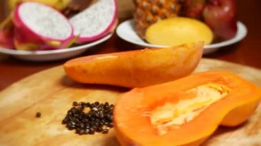 egzotik meyveler masanın üzerinde. 4k, papaya, meyve kesme adet bir kesme tahtası üzerinde döndürmek.