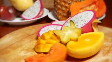 egzotik meyveler masanın üzerinde. 4 k, carambola ve dragon meyve, papaya, mango, mangosten ve longan, tutku meyve, meyve parçaları, bir kesme tahtası üzerinde döndürme kesmek