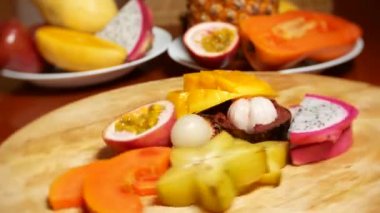 egzotik meyveler masanın üzerinde. 4 k, carambola ve dragon meyve, papaya, mango, mangosten ve longan, tutku meyve, meyve ananas kesme tahtası üzerinde döndürme parçalar halinde kesilmiş.
