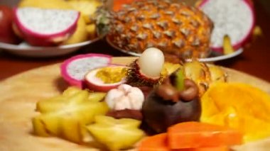 egzotik meyveler masanın üzerinde. 4 k, carambola ve dragon meyve, papaya, mango, mangosten ve longan, tutku meyve, meyve ananas kesme tahtası üzerinde döndürme parçalar halinde kesilmiş.