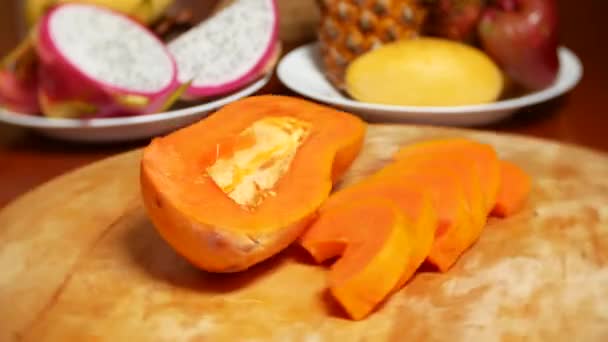 Exotic fruits on the table. 4k, papaya, fruit cut into pieces, rotate on a cutting board. — Stock Video