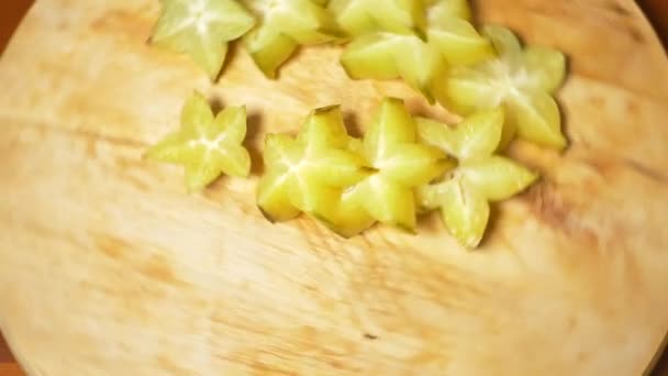 Exotic fruits on the table. 4k , A carambola cut into pieces rotates on a cutting board. — Stock Video