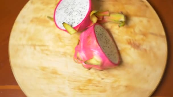 Frutas exóticas na mesa. 4k, o dragonfruit, cortado em pedaços, gira sobre a tábua de corte . — Vídeo de Stock