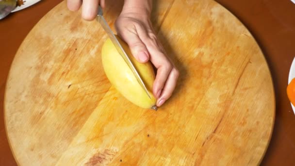Buah eksotis di atas meja. 4k, tangan wanita mempersiapkan mangga di papan potong , — Stok Video
