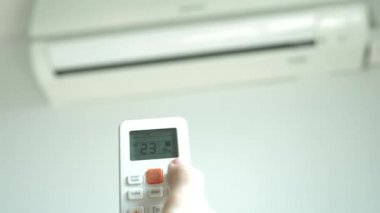 Klima Oda sıcaklığı ayarlamak için elinde bir kablosuz uzaktan kumanda var. 4k, bulanık Klima arka plan üzerinde kontrol panelinin düğmelere basarak el