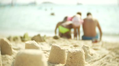 Sahilde, tanınmayan bir aile Kumdan kale halk plajı üzerinde Kumdan kale yapar. 4k, bulanıklık, ağır çekim