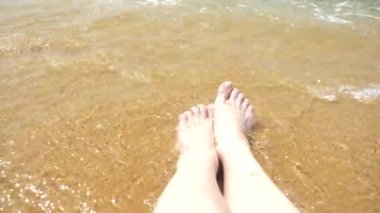 kadın ayakları üzerinde kum dalga deniz kadın bacakları kapsar. 4k, ağır çekim