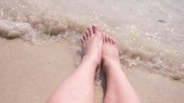 kadın ayakları üzerinde kum dalga deniz kadın bacakları kapsar. 4k, ağır çekim