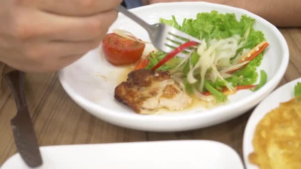Тайская кухня - рис, омлет, овощи со свининой. человек ест тайскую еду в ресторане. 4k, slow motion — стоковое видео