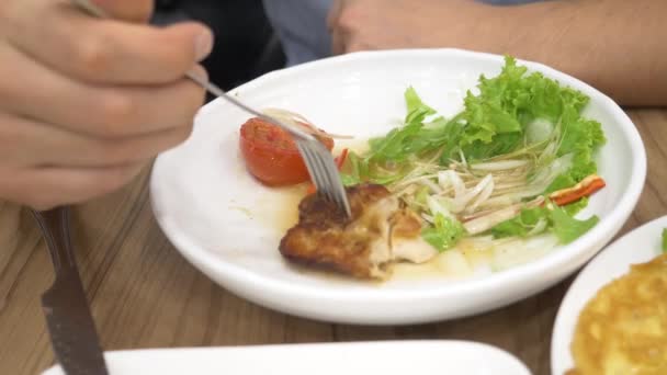 Cozinha tailandesa - arroz, omelete, verduras com o porco. Um homem come comida tailandesa num restaurante. 4k, câmera lenta — Vídeo de Stock