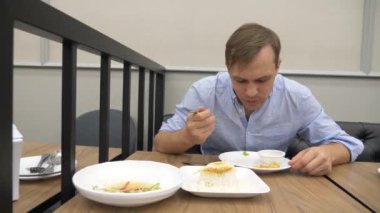 Tayland Mutfağı - pirinç, omlet, domuz eti sebzelerle. bir adam bir restoranda Tayland yemekleri yiyor. 4k, ağır çekim