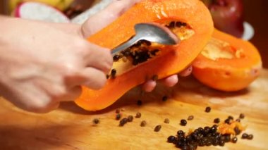 egzotik meyveler masanın üzerinde. 4k, kadın el papaya hazırlamak için bir kesme tahtası