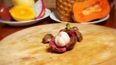 egzotik meyveler masanın üzerinde. 4 k. Mangostin döner kesme tahtası üzerinde