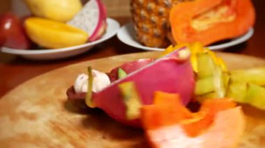 egzotik meyveler masanın üzerinde. 4 k, carambola ve dragon meyve, papaya, mango, mangosten ve longan, tutku meyve, meyve parçaları, bir kesme tahtası üzerinde döndürme kesmek