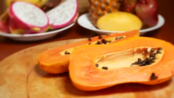 Exotické ovoce na stole. 4k, papája, ovocný plod rozřezaný na kousky, otočit na prkně. — Stock video
