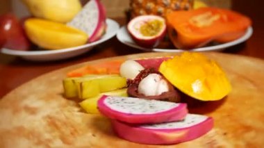 egzotik meyveler masanın üzerinde. 4 k, carambola ve dragon meyve, papaya, mango, mangosten ve longan, tutku meyve, meyve parçaları, bir kesme tahtası üzerinde döndürme kesmek