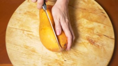 egzotik meyveler masanın üzerinde. 4k, kadın el papaya hazırlamak için bir kesme tahtası