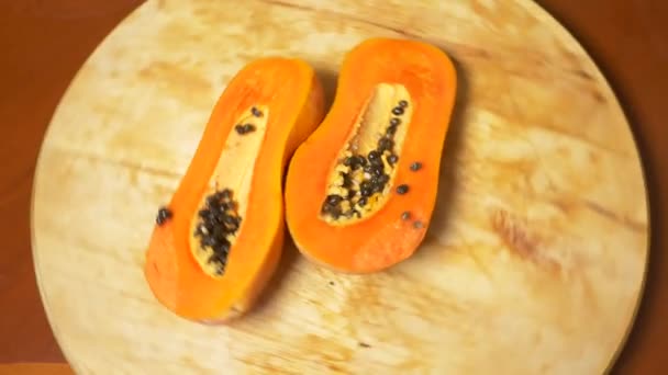 Frutas exóticas en la mesa. 4k, papaya, fruta cortada en trozos, rotar en una tabla de cortar . — Vídeo de stock